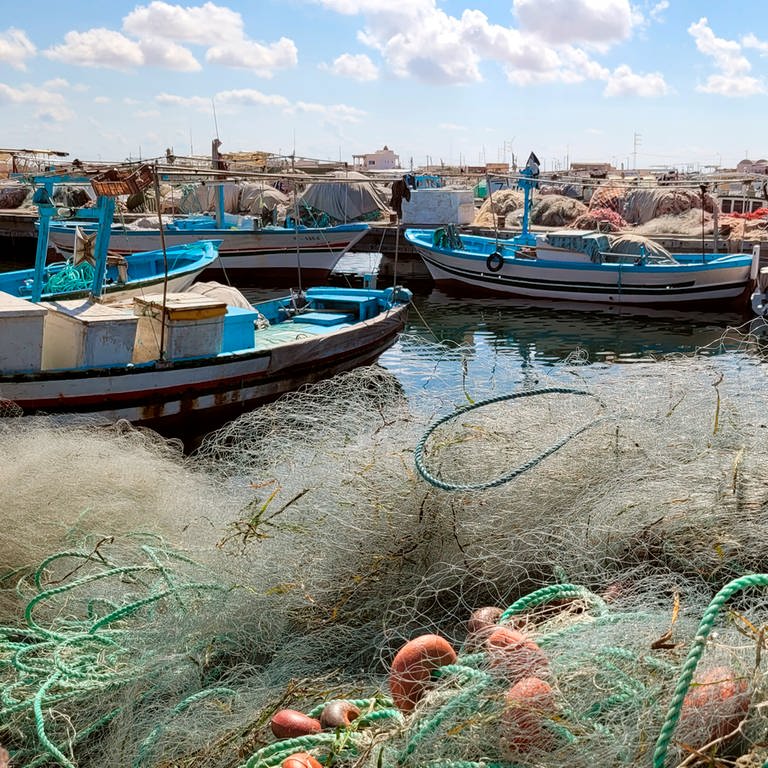 Kleine Fischerboote und Netze in einem Hafen